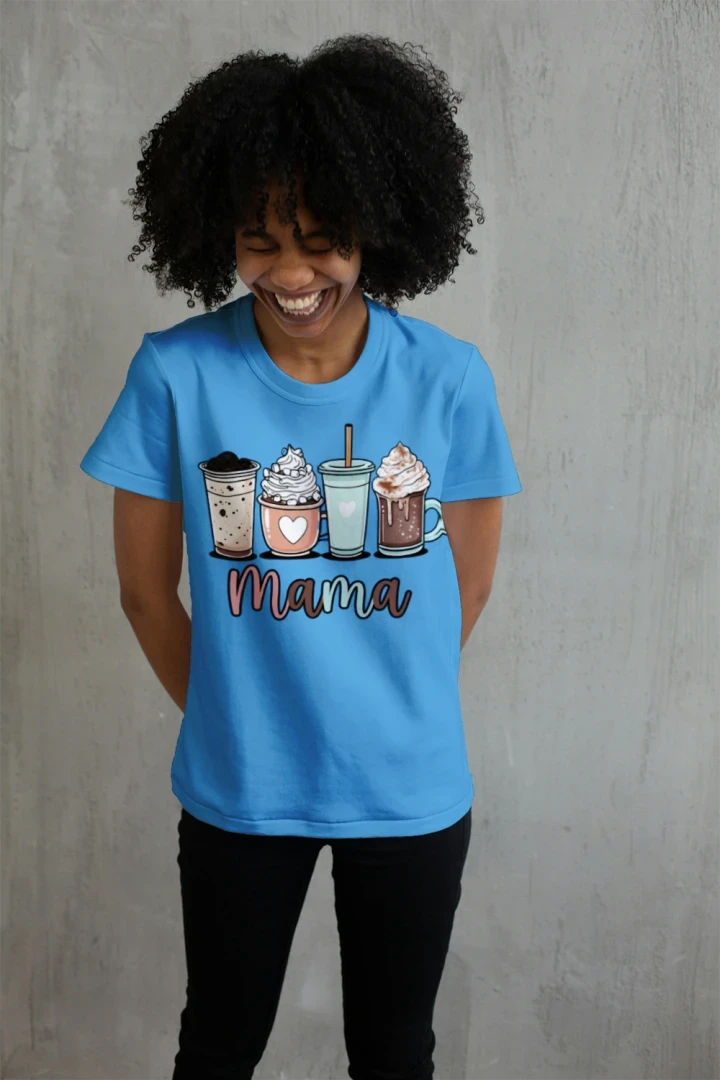 Smiling woman wearing Heather Sapphire Coffee Mama graphic t-shirt with cute illustrated coffee drinks including iced coffee, latte, frappe, and hot chocolate