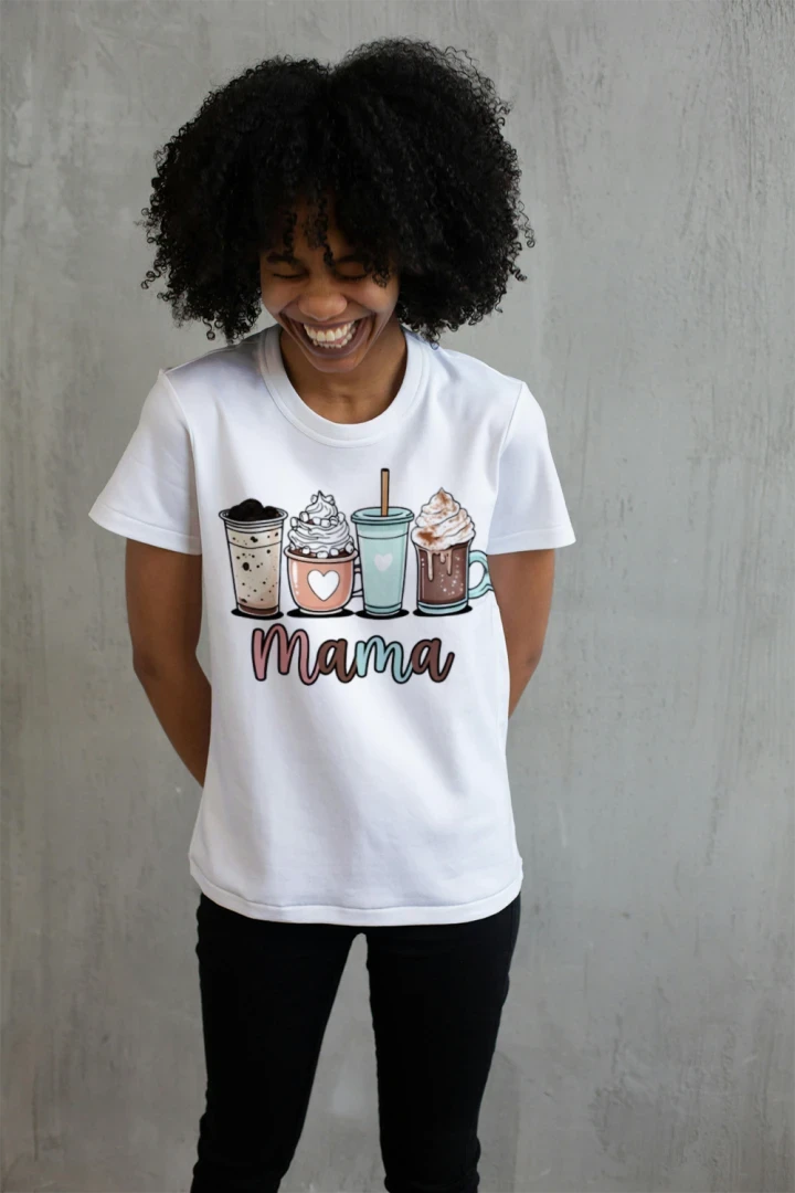 Smiling woman wearing white Coffee Mama graphic t-shirt with cute illustrated coffee drinks including iced coffee, latte, frappe, and hot chocolate