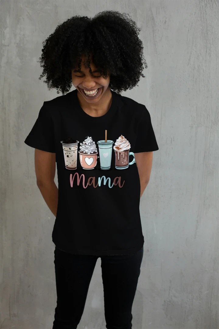 Smiling woman wearing Black Coffee Mama graphic t-shirt with cute illustrated coffee drinks including iced coffee, latte, frappe, and hot chocolate